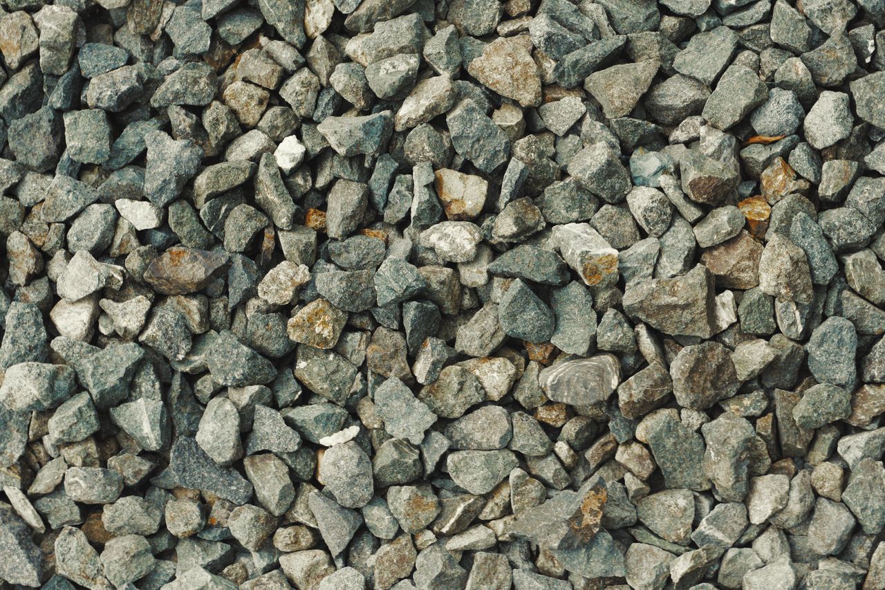 Services A high-resolution image of rough gray gravel stones providing a textured background.