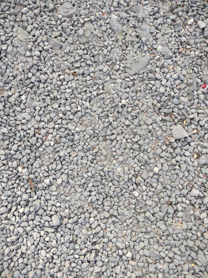Services A detailed close-up of scattered gray pebbles creating a textured stone surface.